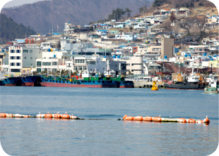 여수 중앙동 지역의 주택과 어선이 보이고 바다 위로 안전부표가 떠있는 중앙동 물양장 시설 사진